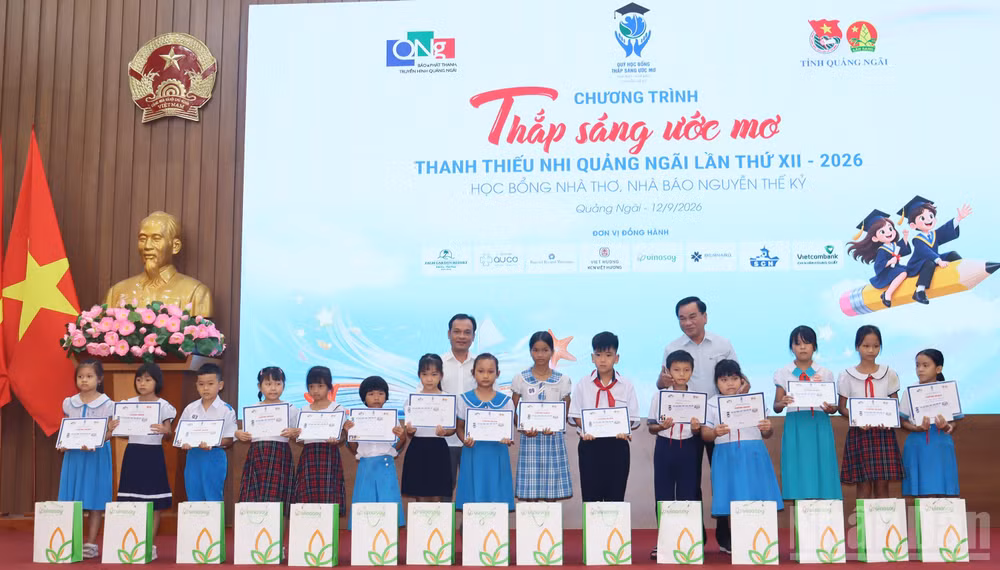 Lãnh đạo tỉnh Quảng Ngãi và đại diện Quỹ học bổng Thắp sáng ước mơ trao học bổng cho học sinh nghèo, vượt khó học giỏi. (Ảnh: HIỂN CỪ)