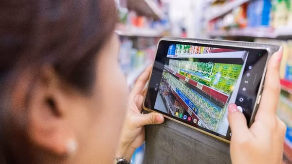 Nhân viên kinh doanh chụp ảnh khu vực trưng bày và tải lên hệ thống DMS của Vinasoy. (Ảnh: AWS)