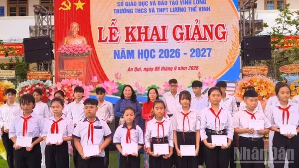 Lãnh đạo tỉnh Vĩnh Long tặng quà học sinh có hoàn cảnh khó khăn tại Trường trung học cơ sở, trung học phổ thông Lương Thế Vinh. (Ảnh: HOÀNG TRUNG)