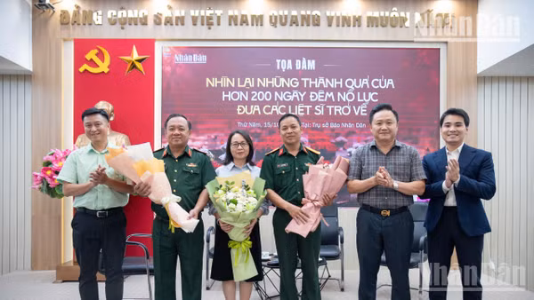 Đồng chí Phan Văn Hùng, Phó Tổng Biên tập Báo Nhân Dân tặng hoa cho các khách mời tham dự tọa đàm trực tuyến “Nhìn lại những thành quả của hơn 200 ngày đêm nỗ lực đưa các liệt sĩ trở về”. Ảnh: MINH DUY.