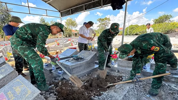 Cán bộ, chiến sĩ Đồn Biên phòng Cửa khẩu cảng Giao Long thực hiện việc cất bốc, quy tập hài cốt liệt sĩ chưa xác định danh tính. (Ảnh: HOÀNG TRUNG)