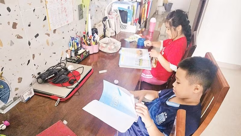 Em Nguyễn Hoàng Trâm Anh (áo đỏ) cùng bạn đang tìm hiểu sách giáo khoa mới.