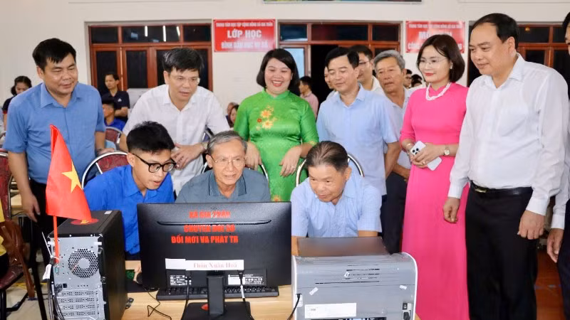 Các đại biểu và người dân tham quan, trải nghiệm thực hiện mô hình "công dân số cộng đồng" và lớp học "Bình dân học vụ số".