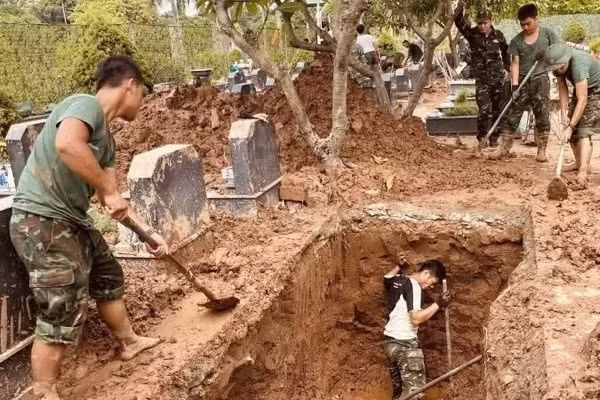 Các lực lượng thực hiện khai quật, lấy mẫu hài cốt liệt sĩ tại Nghĩa trang liệt sĩ Nhổn, phường Tây Tựu, Hà Nội. (Ảnh: MAI HOA)