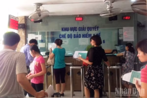 Người dân làm thủ tục đăng ký khám bệnh, chữa bệnh bảo hiểm y tế tại Bệnh viện. (Ảnh: ĐỖ THOA)