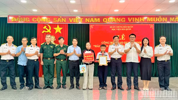Đại tá Hồ Thanh Hòa, Phó Giám đốc Học viện Hải quân trao quyết định “Hải quân nhận đỡ đầu con ngư dân” cho hai cháu có hoàn cảnh khó khăn.