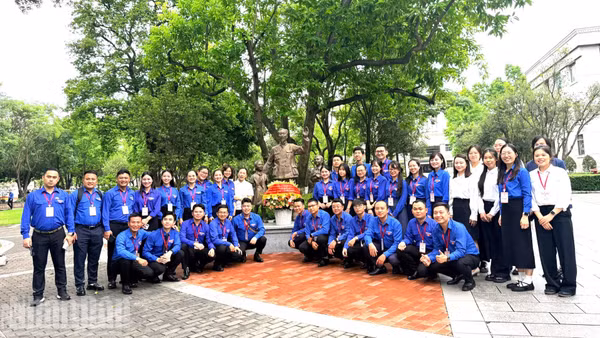 Các đại biểu thanh niên chụp ảnh lưu niệm tại khu vực tượng Bác Hồ trong khuôn viên Đại học Quảng Tây. (Ảnh: HỮU HƯNG)