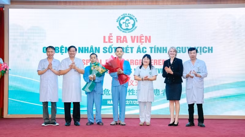 Hai bệnh nhân nhận hoa chúc mừng của thầy thuốc trước khi ra viện.