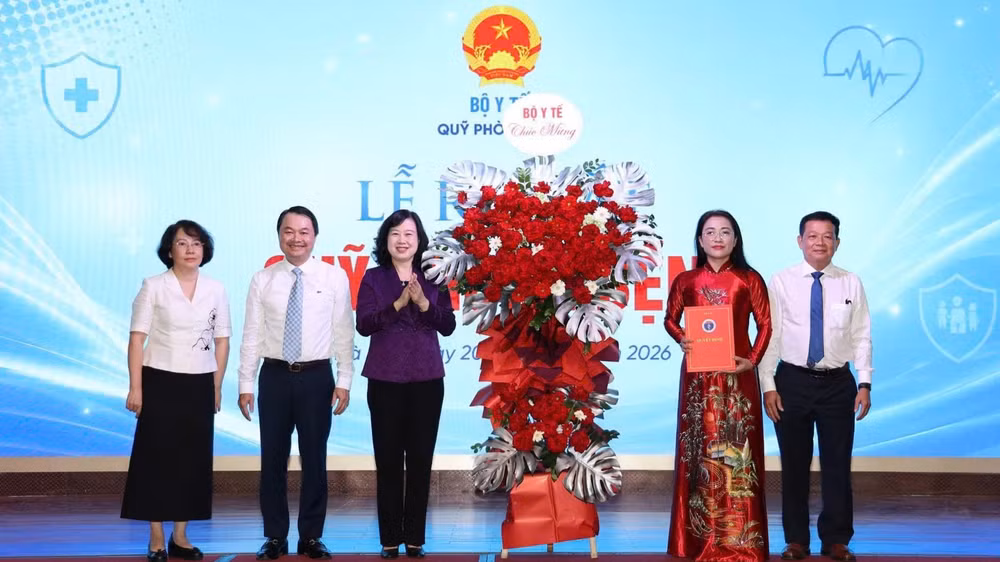 Bộ trưởng Y tế Đào Hồng Lan trao Quyết định và tặng hoa chúc mừng Quỹ Phòng bệnh. (Ảnh: LÊ HẢO)