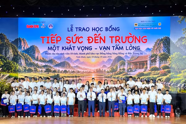 Các đại biểu trao học bổng cho các em học sinh tại buổi lễ. (Ảnh: YẾN TRINH)