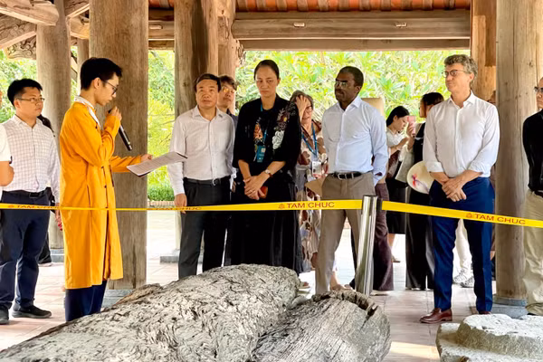 Đoàn đại biểu tham quan những hiện vật khảo cổ được trưng bày tại đình Tam Chúc. (Ảnh: YẾN TRINH)