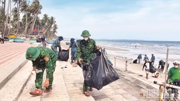 Các lực lượng đoàn thể cùng với người dân tham gia nhặt rác bãi biển bảo vệ môi trường. 