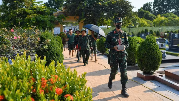 Hài cốt liệt sĩ được cán bộ, chiến sĩ đưa ra khu vực lấy mẫu ADN. (Ảnh: THẾ ĐẠI)