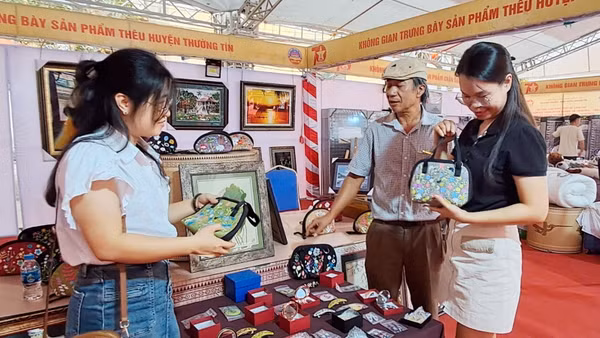 Nghệ nhân làng nghề giới thiệu các sản phẩm thủ công mỹ nghệ, quà tặng tới khách hàng. (Ảnh: Nguyên Trang) 