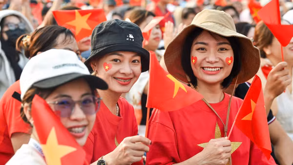Từ sớm, từng dòng người đã đổ về khu vực tổ chức lễ kỷ niệm, mang theo lá cờ đỏ sao vàng rực rỡ cùng niềm tự hào hiện rõ trên từng ánh mắt, nụ cười. (Ảnh: THÀNH ĐẠT)