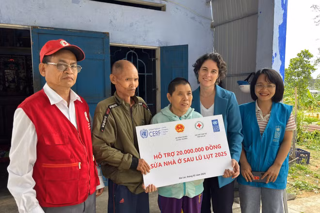 Đại diện Chương trình Phát triển Liên hợp quốc (UNDP) trao tiền hỗ trợ cho gia đình bị ảnh hưởng bởi bão lũ.