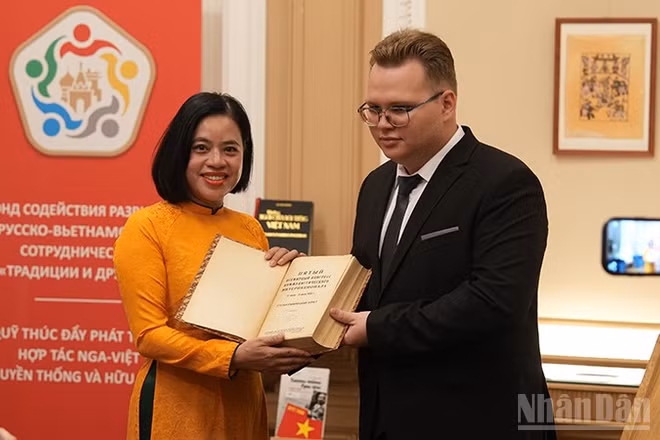 Sinh viên Trường MGIMO trao tặng Bảo tàng Hồ Chí Minh cuốn sách in bài phát biểu của Bác Hồ tại Đại hội lần thứ V Quốc tế Cộng sản. (Ảnh: XUÂN HƯNG)