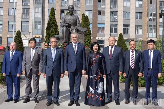 Các đại biểu Việt Nam và Nga chụp ảnh tại Tượng đài Chủ tịch Hồ Chí Minh ở Saint Petersburg. (Ảnh: XUÂN HƯNG)