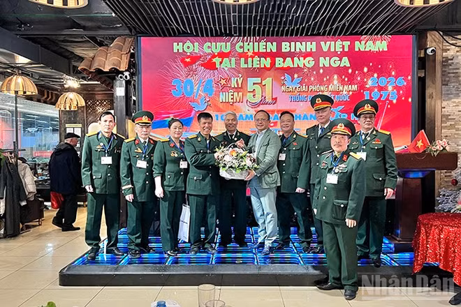 Chủ tịch Liên hiệp các tổ chức người Việt Nam tại Liên bang Nga Đỗ Xuân Hoàng tặng hoa chúc mừng Hội Cựu chiến binh Việt Nam tại Liên bang Nga. (Ảnh: XUÂN HƯNG)