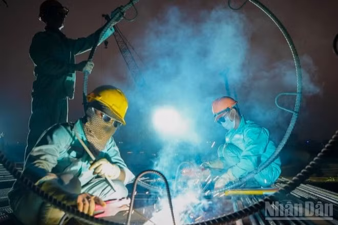 Những ngày cận Tết Nguyên đán, ngày cũng như đêm, trên công trường xây dựng cầu Trần Hưng Đạo (Hà Nội), nhịp độ lao động vẫn hết sức sôi động, khẩn trương.