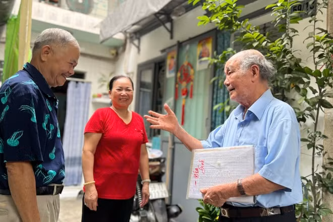 Ông Nguyễn Khắc Êm (áo xanh) trò chuyện cùng người dân trong khu phố. 