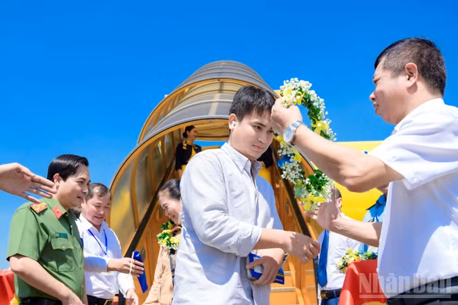 Đại diện lãnh đạo tỉnh Thanh Hóa chào đón những hành khách đầu tiên trên chuyến bay của Vietravel đến Cảng Hàng không Thọ Xuân. (Ảnh: MỸ YẾN)