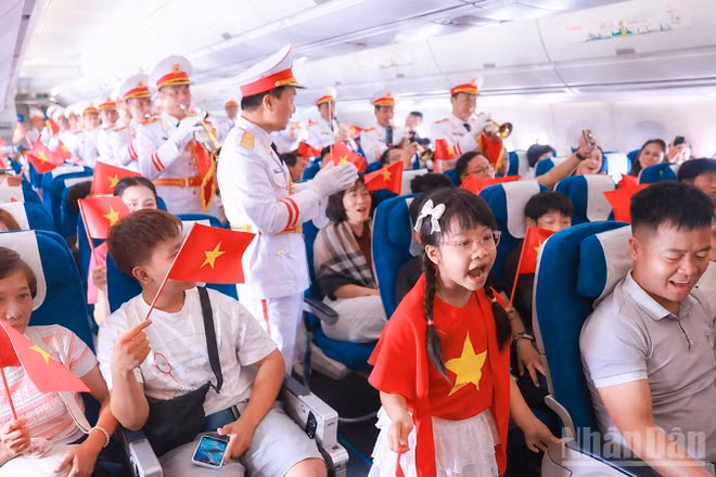 Các hành khách, hoa hậu Việt Nam và Đoàn Nghi lễ Quân đội cất cao tiếng hát. (Ảnh: TRUNG PHONG)