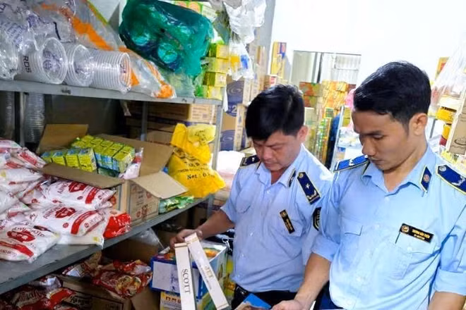 Lực lượng chức năng kiểm soát các điểm bán thuốc lá trên thị trường. (Ảnh: BĂNG TÂM)