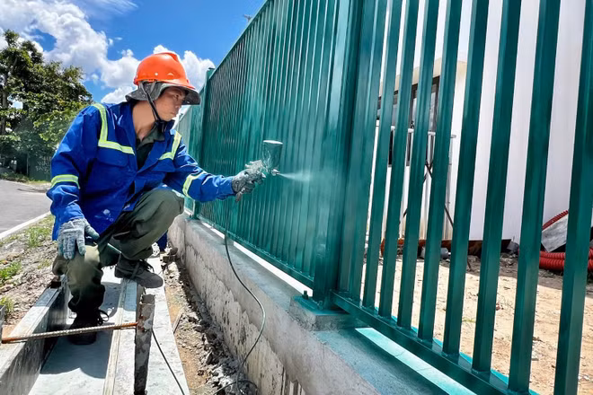 Công nhân sơn tường rào tại dự án ngăn triều Tân Thuận.
