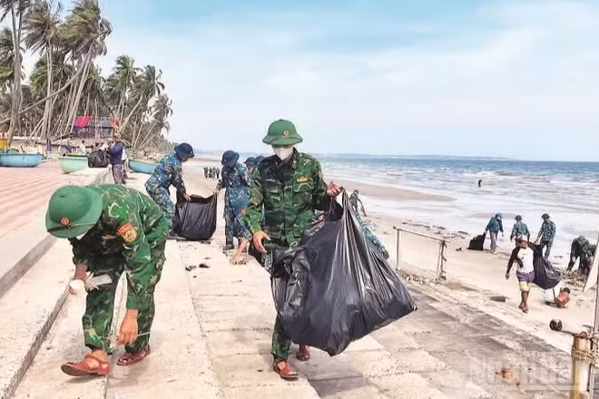 Các lực lượng đoàn thể cùng với người dân tham gia nhặt rác bãi biển bảo vệ môi trường. 