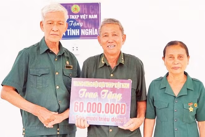 Vợ chồng ông Nguyễn Xuân Thanh trong ngày nhận Nhà nghĩa tình đồng đội. (Ảnh: PHẠM HẠNH)