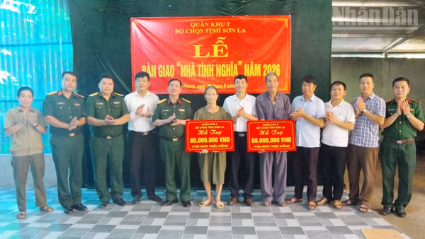 Lãnh đạo Bộ Chỉ huy Quân sự tỉnh Sơn La và xã Tân Phong trao tiền hỗ trợ làm nhà cho các gia đình chính sách. (Ảnh: THỌ SƠN)