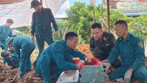 Lực lượng tham gia tiến hành khai quật, cất bốc 2 hài cốt liệt sĩ tại xã Chiềng Khoong, tỉnh Sơn La. (Ảnh: THỌ SƠN)