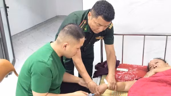 Cán bộ, chiến sĩ Trạm Kiểm soát Biên phòng Keo Muông thực hiện sơ cứu ban đầu cho bà Tếnh Thị Mo, xã Lao Húng Phiêng Xa, huyện Xiềng Khọ, tỉnh Hủa Phăn, nước bạn Lào. (Ảnh: QUÀNG HÙNG)