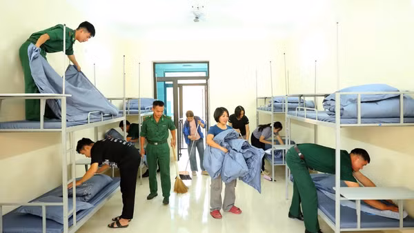 Cán bộ, chiến sĩ Đồn Biên phòng Chiềng On, Ban Chỉ huy Bộ đội Biên phòng tỉnh Sơn La phối hợp giáo viên chuẩn bị chỗ ngủ nghỉ cho các cháu học sinh nội trú. (Ảnh: QUÀNG HÙNG)