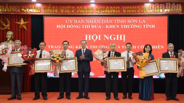 Đồng chí Nguyễn Đình Việt, Chủ tịch Ủy ban nhân dân tỉnh Sơn La và Phan Văn Hùng, Phó trưởng Ban Thi đua-Khen thưởng Trung ương trao Huân chương Lao động hạng Nhì cho các cá nhân. (Ảnh: QUỐC TUẤN)