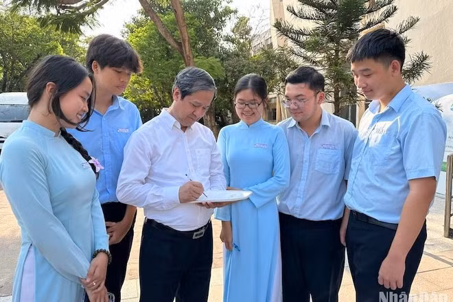Bộ trưởng Nguyễn Kim Sơn và các em học sinh Trường trung học phổ thông chuyên Lê Quý Đôn, thành phố Đà Nẵng. (Ảnh: Báo Nhân Dân)