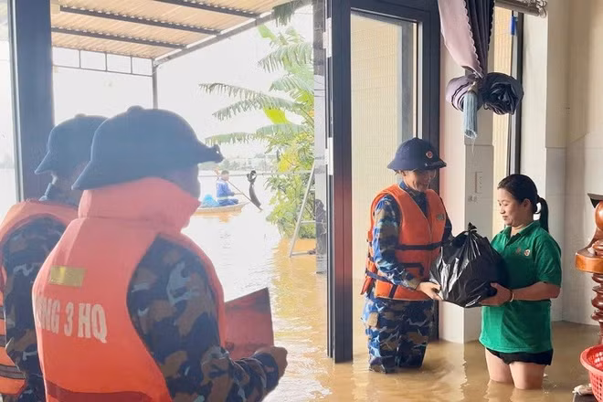 Cán bộ, chiến sĩ Vùng 3 Hải quân vận chuyển hàng trăm phần quà gồm gạo, lương khô, mỳ tôm, nước suối và sữa trao tận tay người dân vùng lũ. (Ảnh: VÙNG 3 HẢI QUÂN)