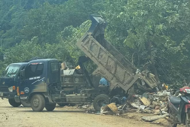 Xe chở chất thải được thu gom từ những tuyến đường bị ngập úng đổ trên vỉa hè đường Phùng Hưng, phường Hà Giang 2.