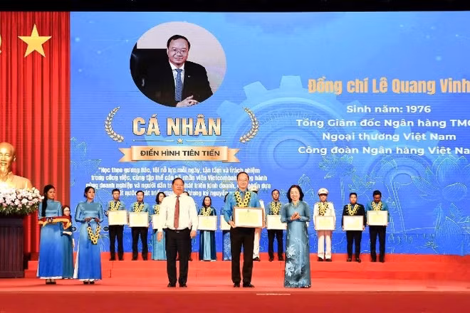 Đồng chí Nguyễn Phi Long, Ủy viên Trung ương Đảng, Phó Bí thư Thường trực Đảng ủy Mặt trận Tổ quốc các đoàn thể Trung ương, Phó Chủ tịch Ủy ban Trung ương Mặt trận Tổ quốc Việt Nam (bên trái) trao hoa chúc mừng và đồng chí Thái Thu Sương, Phó Chủ tịch thường trực Tổng Liên đoàn Lao động Việt Nam (bên phải) trao bằng khen cho đồng chí Lê Quang Vinh.