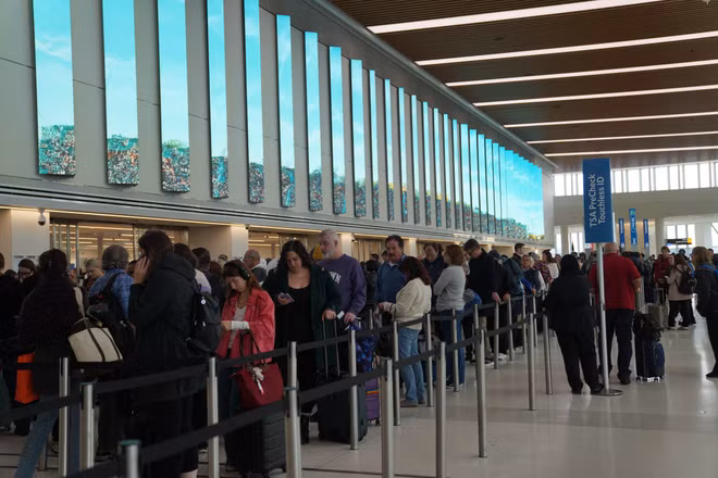 Hành khách xếp hàng chờ làm thủ tục tại sân bay LaGuardia ở New York, Mỹ. (Ảnh: THX/TTXVN)