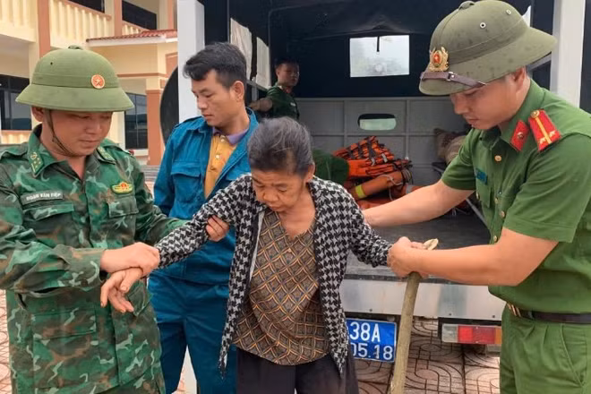 Cán bộ, chiến sĩ Đồn Biên phòng bản Giàng phối hợp đưa người dân về khu vực an toàn.