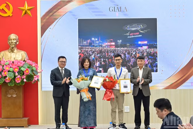 Tổng Biên tập Báo Nhân Dân Lê Quốc Minh trao giải cho các tác giả có tác phẩm đạt giải A. 