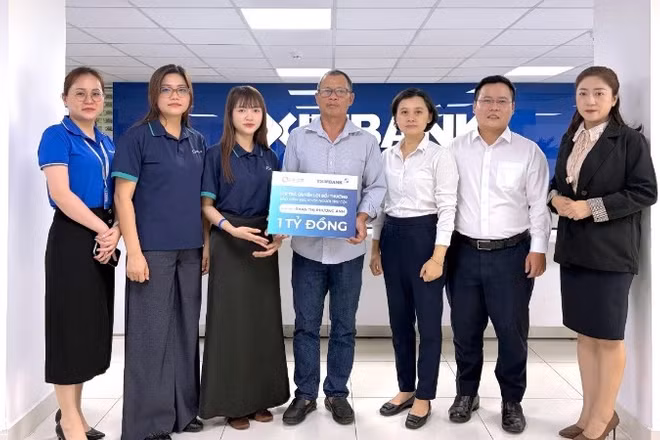 Đại diện OPES và Eximbank chi trả quyền lợi bảo hiểm cho gia đình khách hàng.