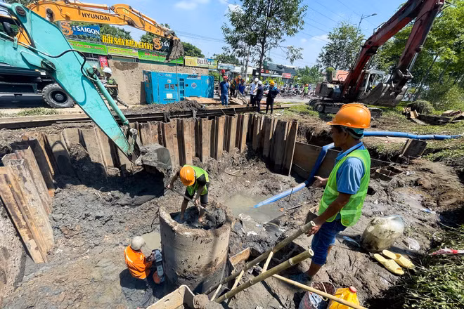Công nhân kỹ thuật xử lý sự cố bể đường ống cấp nước tại tuyến đường Phạm Văn Đồng.