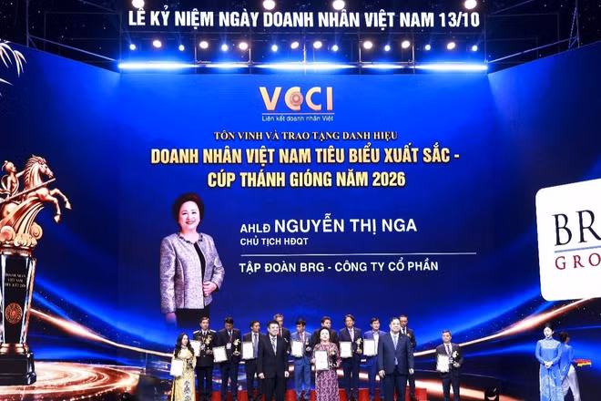 Đồng chí Phạm Gia Túc, Ủy viên Bộ Chính trị, Phó Thủ tướng Thường trực Chính phủ và đồng chí Hồ Sỹ Hùng, Chủ tịch Liên đoàn Thương mại và Công nghiệp Việt Nam trao tặng Cúp Thánh Gióng cho Anh hùng Lao động Nguyễn Thị Nga. (Ảnh: Thu Thảo)